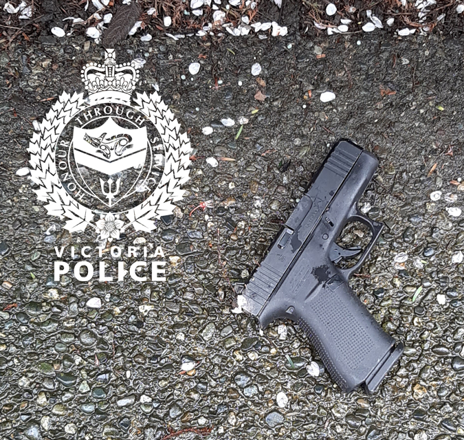 A loaded handgun lays on the pavement where it was recovered by officers