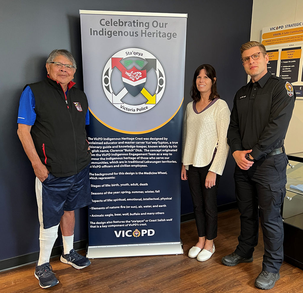 Yux’wey’lupton, also known as “Butch” Dick, VicPD Indigenous Engagement Team member Det. Cst. Sandi Haney and Cst. Cam MacIntyre at the unveiling of VicPD’s Indigenous Heritage Crest banner